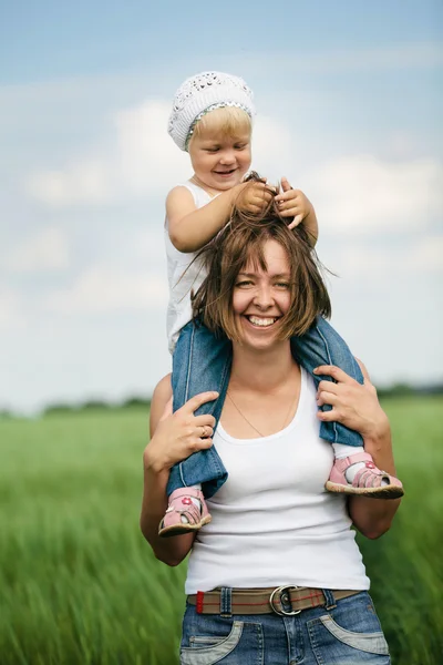 Gelukkig moeder met dochter in het veld — Stockfoto