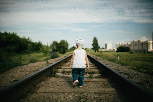 Liten flicka spelar på järnvägen — Stockfoto