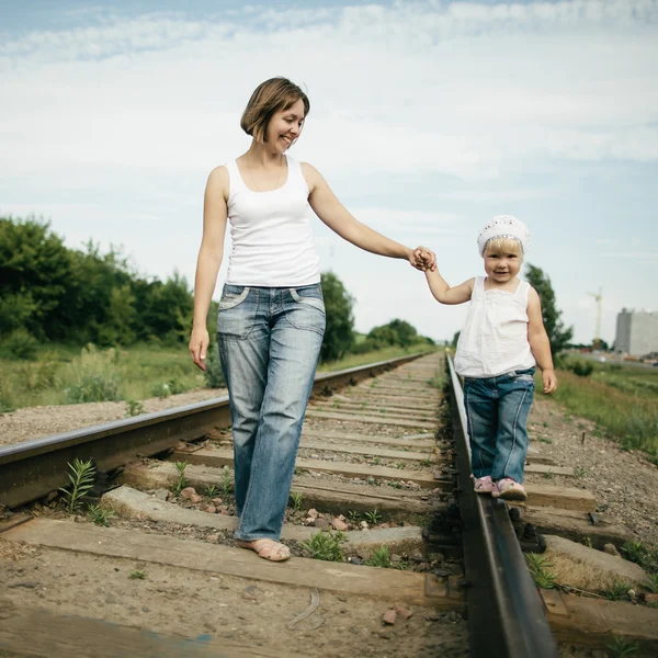 Mãe feliz com bebê na estrada de ferro — Fotografia de Stock