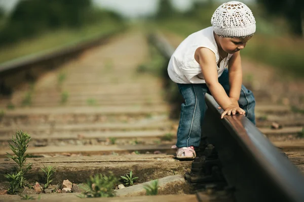 Little girl plays on railroad — Stock Photo, Image