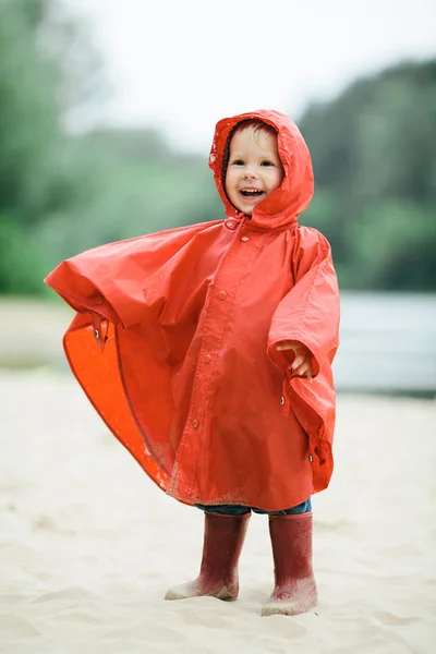 Kleines lustiges Mädchen mit Regenmantel — Stockfoto