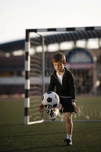 Niño juega al fútbol en el estadio —  Fotos de Stock