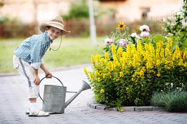 Bambino con annaffiatoio nel parco estivo — Foto Stock