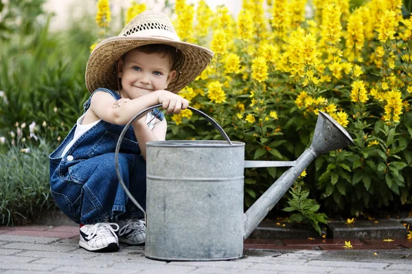 Liten pojke med vattenkanna i sommaren park — Stockfoto