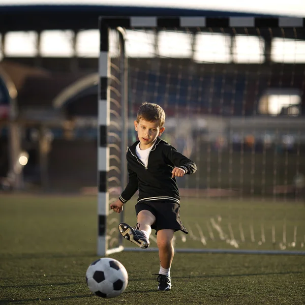 Anak laki-laki bermain sepak bola di stadion — Stok Foto