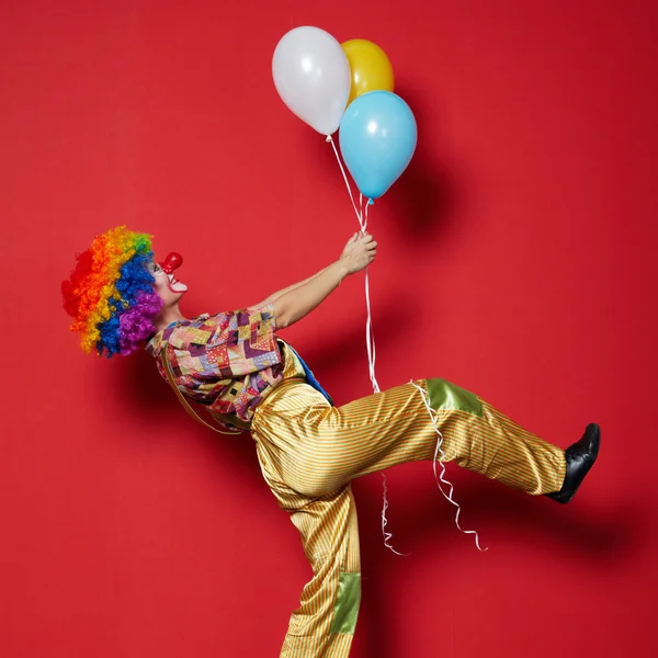 Clown met ballonnen op rode achtergrond — Stockfoto