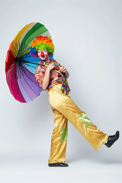 Clown con ombrello colorato su bianco — Foto Stock