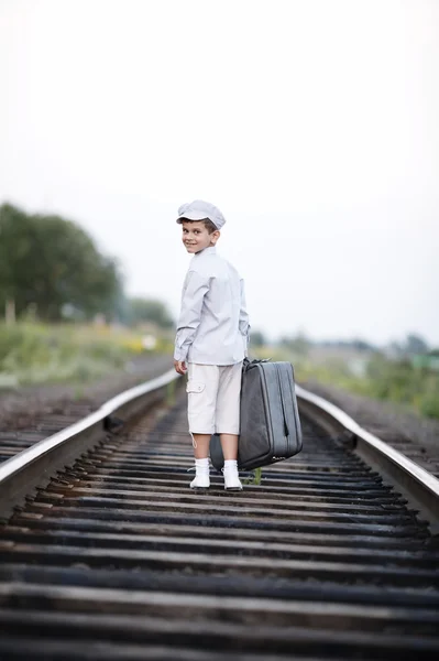 Pojke med resväska på järnvägen — Stockfoto