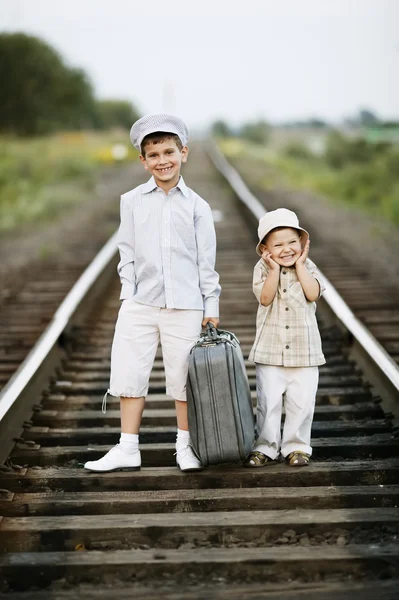 Deux garçons avec valise sur les chemins de fer — Photo