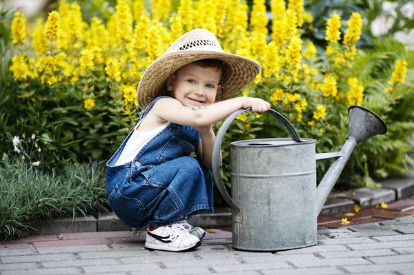 Niño pequeño con regadera en el parque de verano —  Fotos de Stock