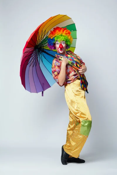 Clown con ombrello colorato su bianco — Foto Stock