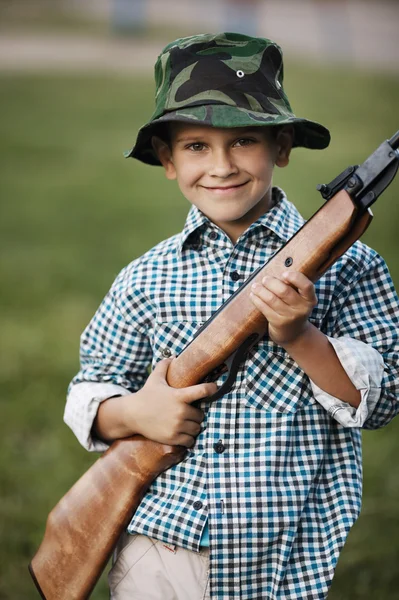 Маленький мальчик с пневматическим пистолетом на улице — стоковое фото