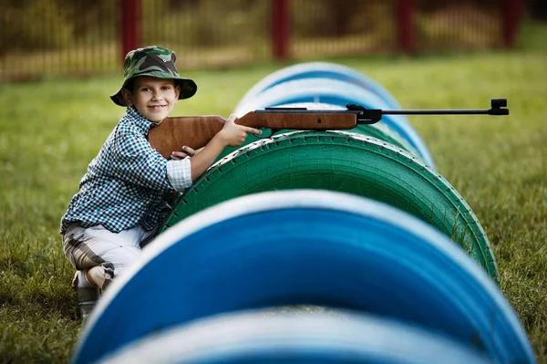 Liten pojke med luftgevär utomhus — Stockfoto