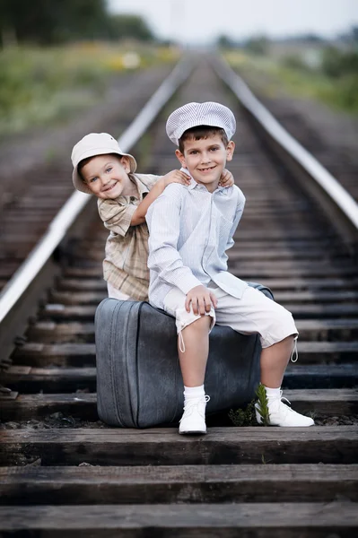 Dois meninos com mala em ferrovias — Fotografia de Stock