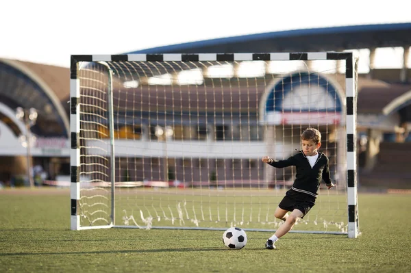 Jongen speelt voetbal op stadion — Stockfoto