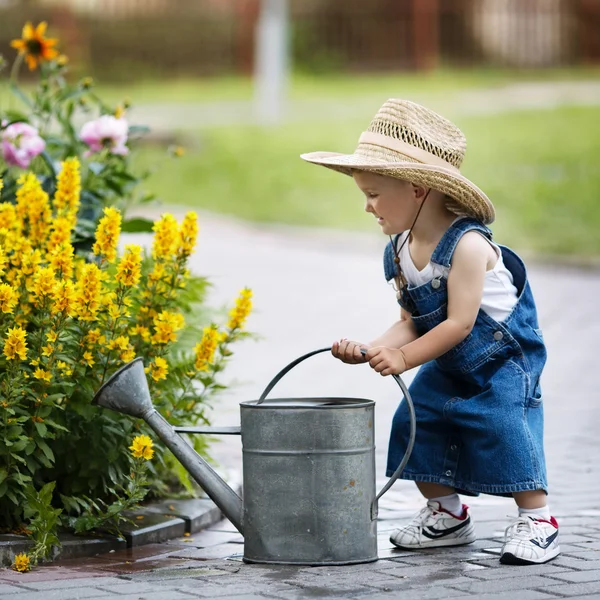 Liten pojke med vattenkanna i sommaren park — Stockfoto