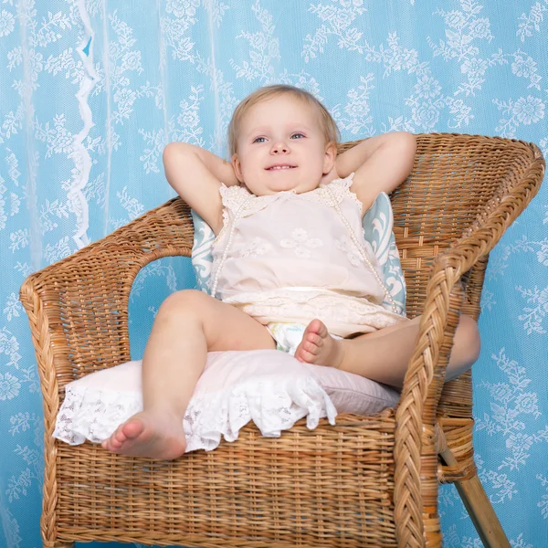 Niña descansando en silla de ratán — Foto de Stock