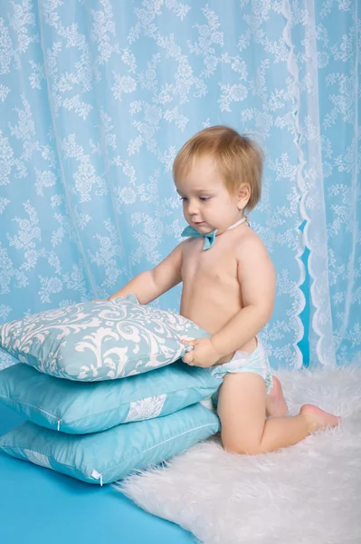 Boy plays with pillows studio portrait — Stock Photo, Image