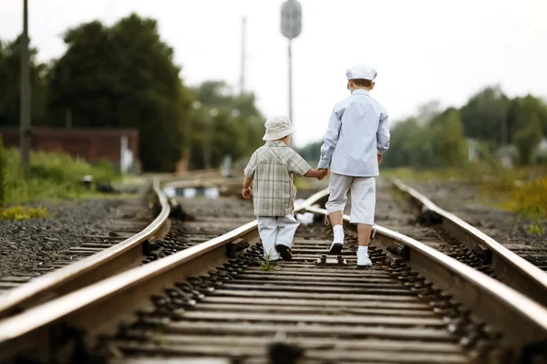 Dva chlapci s kufrem na železnici — Stock fotografie
