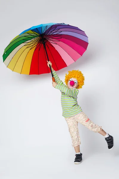 Palhaço com guarda-chuva colorido no branco — Fotografia de Stock