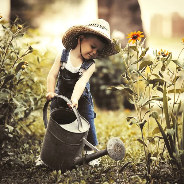 Anak kecil dengan kaleng air di taman musim panas — Stok Foto