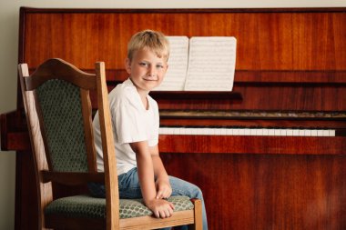 küçük mutlu çocuk piyano çalıyor