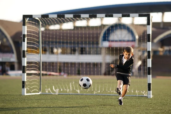 Anak laki-laki bermain sepak bola di stadion — Stok Foto