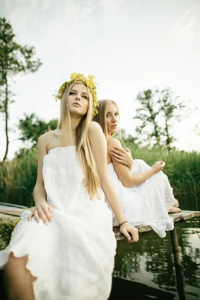 Two beautiful girls on coast at pier — Stock Photo, Image