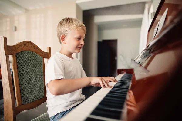 Little happy boy plays piano — Stock Photo, Image