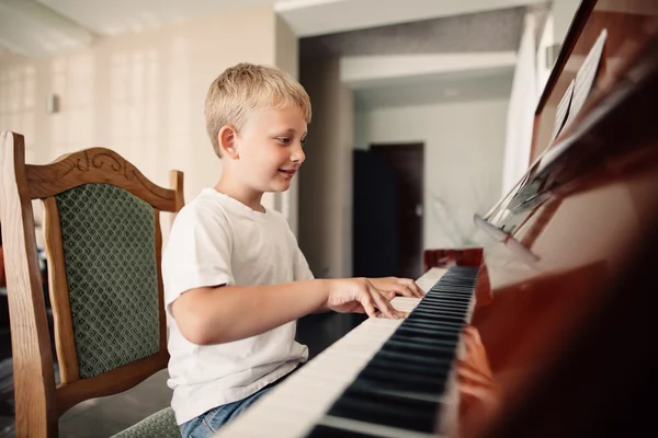 快乐的小男孩弹钢琴 免版税图库图片