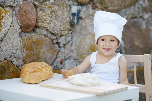 Kleine jongen met chef-kok hoed koken — Stockfoto