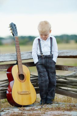 gitar konumunda olan küçük çocuk