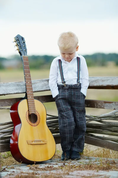 Liten pojke med gitarr på plats — Stockfoto