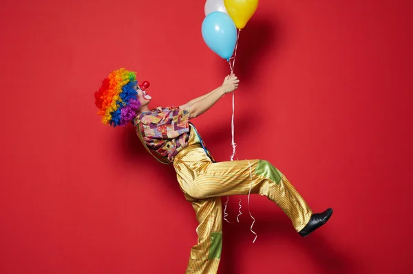 Payaso con globos sobre fondo rojo — Foto de Stock