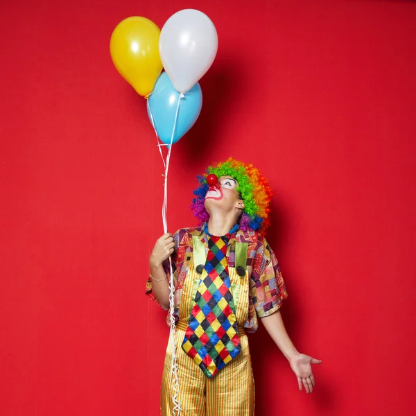 Payaso con globos sobre fondo rojo — Foto de Stock