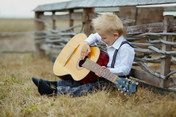 Liten pojke med gitarr på plats — Stockfoto