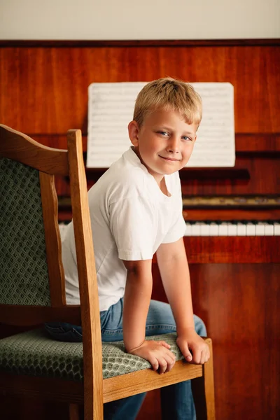 Liten glad pojke spelar piano — Stockfoto