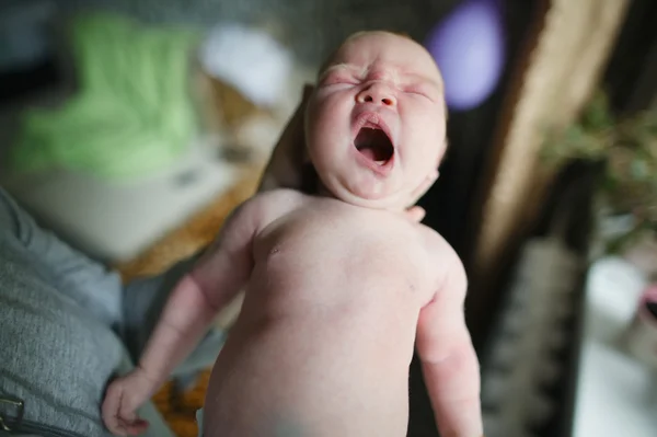 Mãe segura choro bebê em mãos — Fotografia de Stock