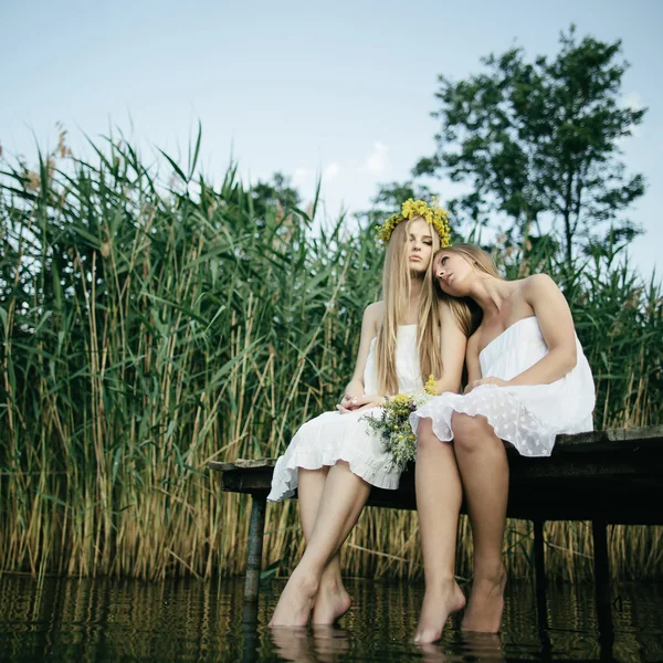 Dvě krásné dívky na pobřeží na molu — Stock fotografie