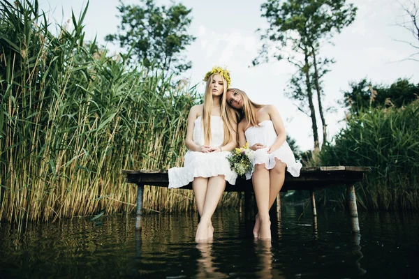 Dos hermosas chicas en la costa en el muelle — Foto de Stock