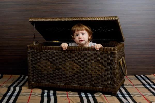 Kleines Mädchen sitzt im Koffer — Stockfoto