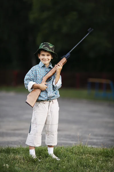 Liten pojke med luftgevär utomhus — Stockfoto
