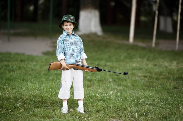 Liten pojke med luftgevär utomhus — Stockfoto