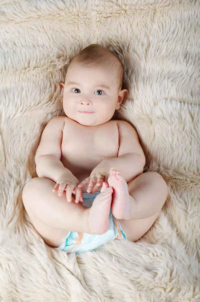 Portret van de schattige baby liggend op bont — Stockfoto