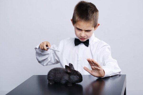 little magician with rabbit studio shot