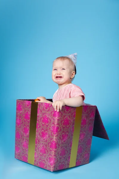 Triste niña con gorra de cumpleaños sentado en caja de regalo —  Fotos de Stock