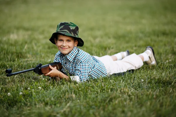 Liten pojke med luftgevär utomhus — Stockfoto