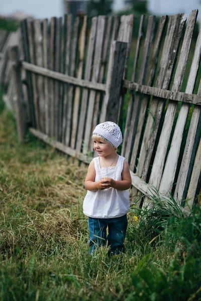 Маленька дівчинка і дерев'яний паркан — стокове фото
