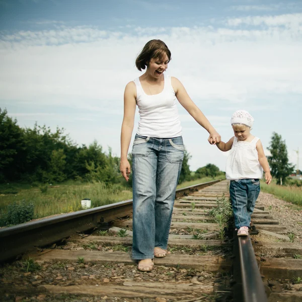 Mãe feliz com bebê na estrada de ferro — Fotografia de Stock