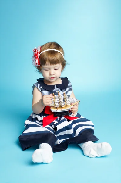 Girl in a sea clothes with model ship — Stock Photo, Image